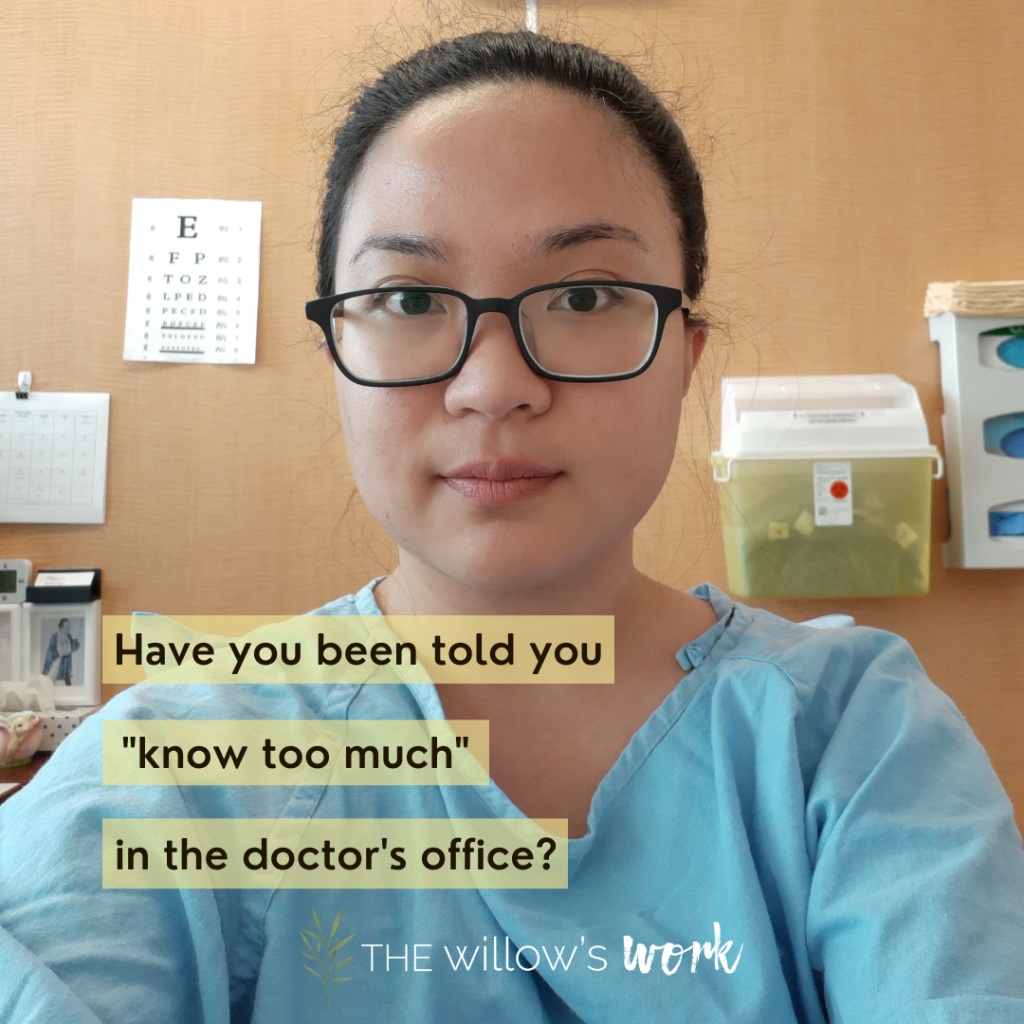 An image of Kaia, an Asian woman with glasses smiling softly directly into the camera. Black text on semi-transparent yellow blocks reads, “have you ever been told you ‘know too much’ in the doctor’s office?”. Kaia is wearing a blue hospital gown, with a wooden wall behind her and a yellow sharps box, haphazardly pinned eye exam chart, and other paraphernalia on the wall. ⁣